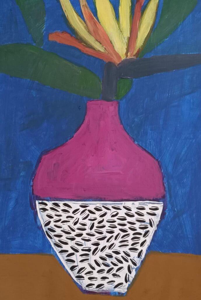 A vase with a Bird of Paradise flower and sunflower seeds.